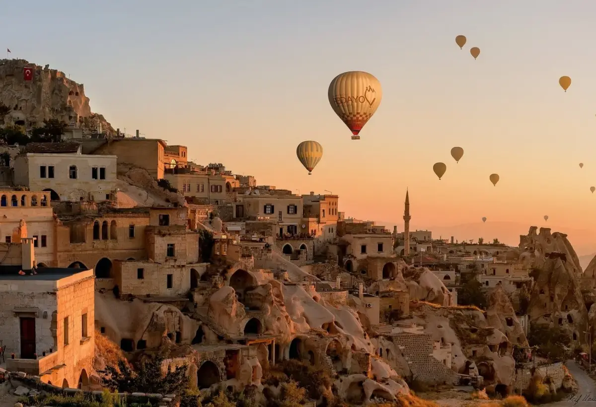 Cave houses cut into a Cappadocian hillside in the first light of morning.